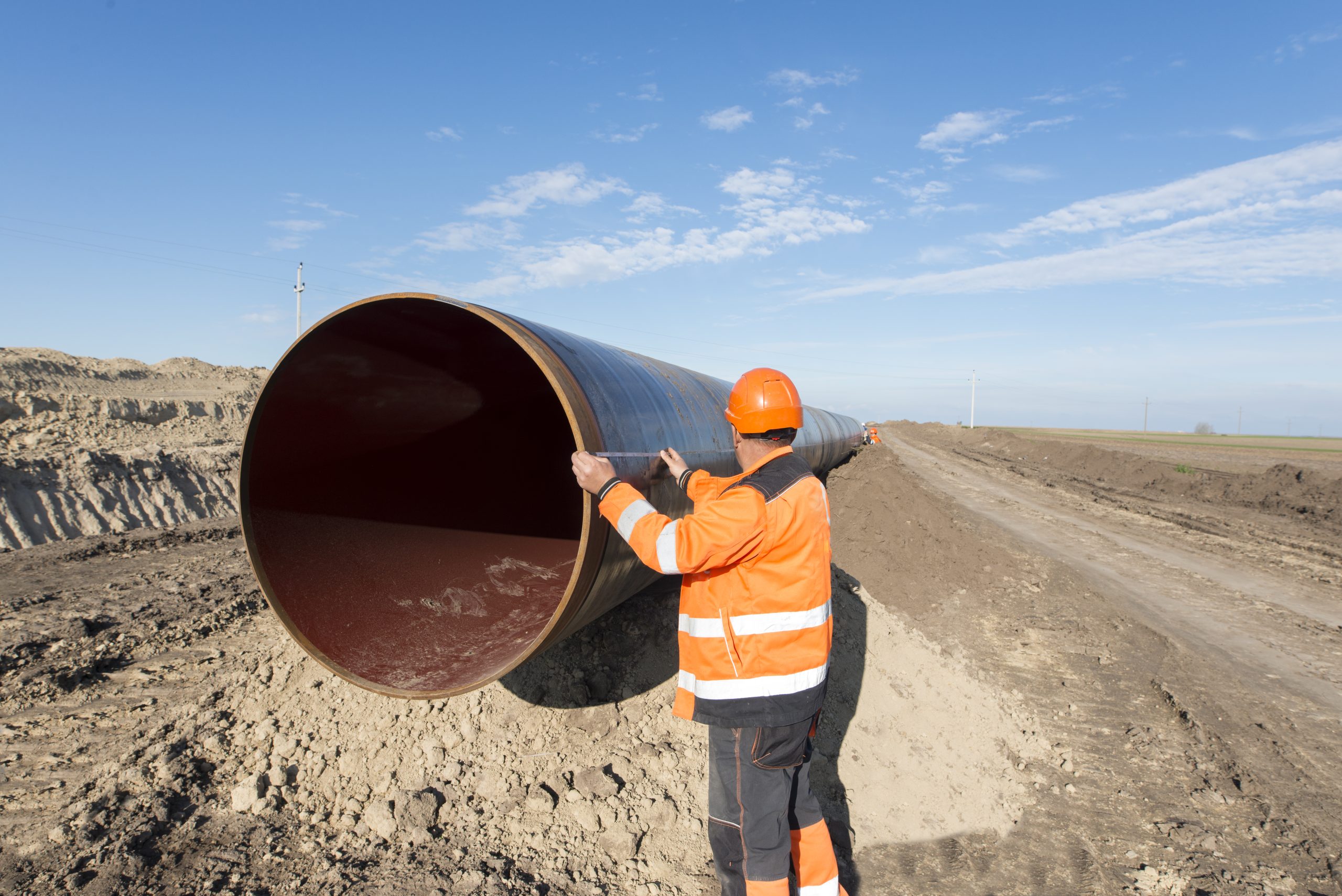 pipeline workers measuring tube length construction gas oil pipes scaled